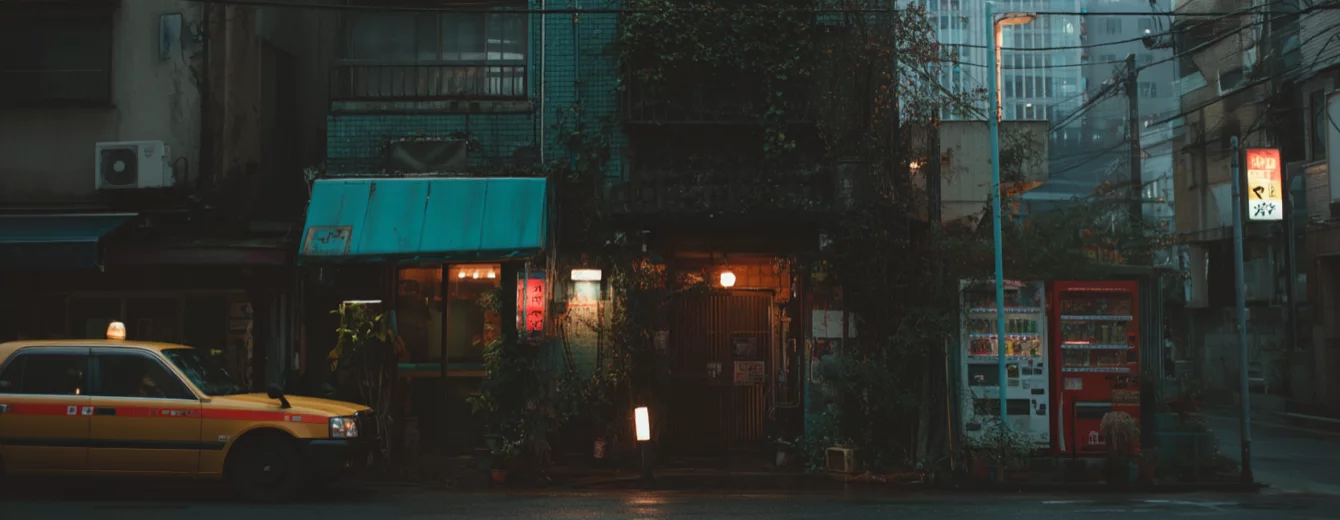 After hours inner city street scene in evening hours with taxi in front of buildings and two vending machines